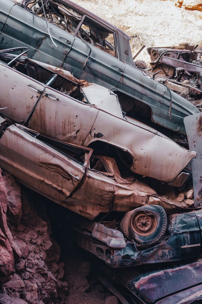Vertical shot of stacked abandoned cars in a junkyard, conveying decay and urban exploration.